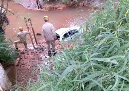 Corpos são retirados de veículo encontrado dentro de córrego; sobrevivente dormia próximo ao local