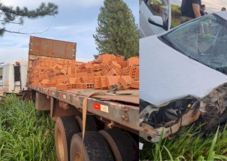 Mulher fica ferida em acidente entre carro e caminhão de tijolos